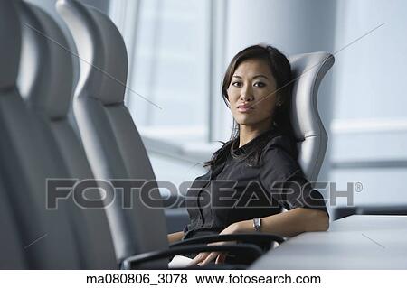 Asian businesswoman sitting in conference room View Large Photo Image Stock Photo - Asian businesswoman sitting in conference room. Fotosearch