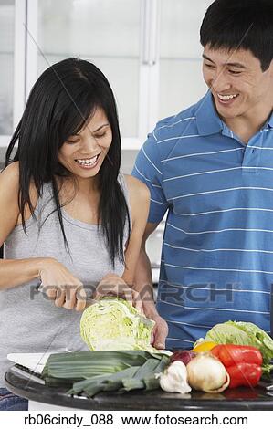 Asian couple chopping vegetables in kitchen View Large Photo Image Stock Photo - Asian couple chopping vegetables in kitchen. Fotosearch