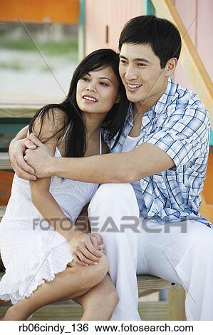 Stock Photograph - Asian couple hugging on stairs. Fotosearch