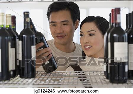 Asian couple selecting wine View Large Photo Image Stock Photograph - Asian couple selecting wine. Fotosearch