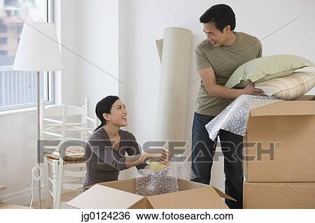 Asian couple unpacking boxes View Large Photo Image Stock Photograph - Asian couple unpacking boxes. Fotosearch