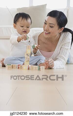 Asian mother and baby playing with blocks on floor View Large Photo Image Stock Image - Asian mother and baby playing with blocks on floor. Fotosearch