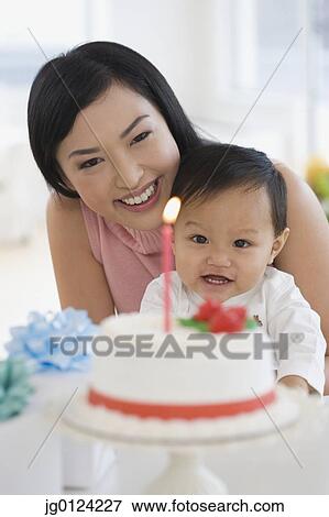 Stock Photo - Asian mother celebrating baby's first birthday. Fotosearch