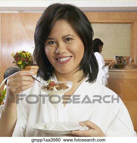 Asian woman in spa bathrobe eating cereal in glass View Large Photo Image Stock Image - Asian woman in spa bathrobe eating cereal in glass. Fotosearch
