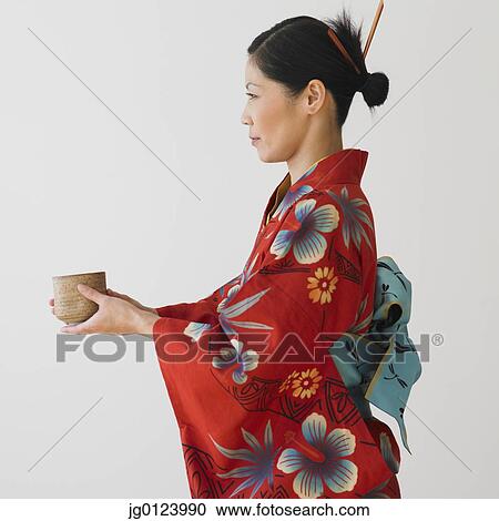 Asian woman in traditional dress holding bowl View Large Photo Image Stock Image - Asian woman in traditional dress holding bowl. Fotosearch
