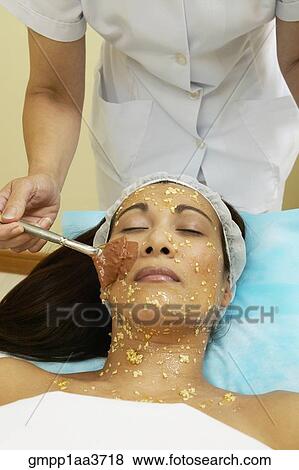 Stock Photo - Asian woman receiving facial spa treatment. Fotosearch