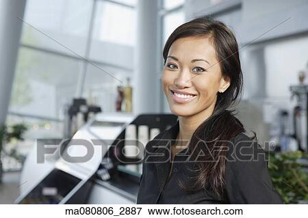 Stock Photo - Asian woman smiling indoors. Fotosearch