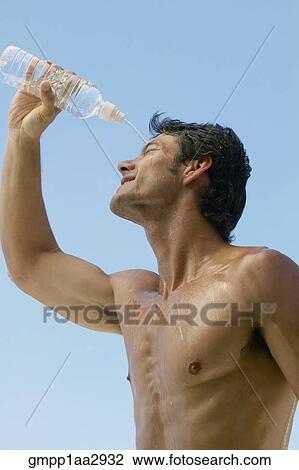 Stock Image - Bare-chested Asian man pouring water over head. Fotosearch