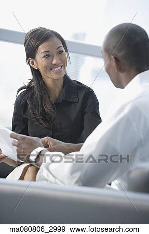 Businessman and businesswoman talking in office lobby View Large Photo Image Stock Photo - Businessman and businesswoman talking in office lobby. Fotosearch