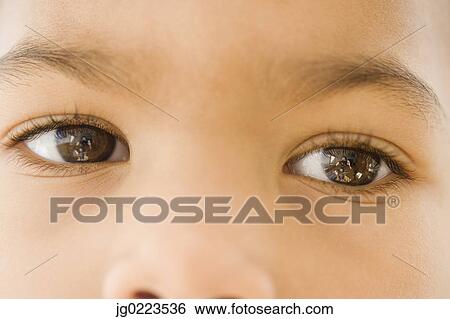 Stock Photograph - Close up of African girl’s eyes. Fotosearch