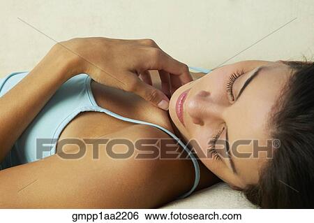 Stock Photograph - Close up of Hispanic woman laying down with eyes closed. Fotosearch