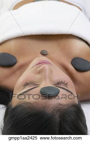 Close up of Hispanic woman with stone spa treatment View Large Photo Image Stock Photography - Close up of Hispanic woman with stone spa treatment. Fotosearch