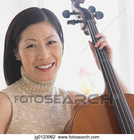 Stock Image - Close up of Middle-aged Asian woman with cello. Fotosearch