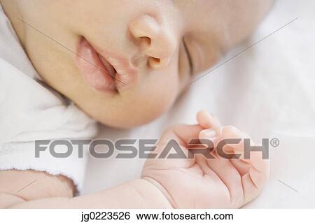 Stock Photograph - Close up of sleeping newborn baby. Fotosearch