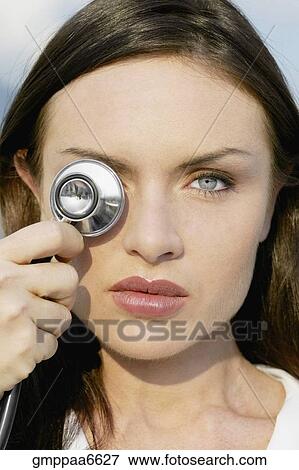 Close up of woman holding stethoscope over eye View Large Photo Image Stock Photo - Close up of woman holding stethoscope over eye. Fotosearch