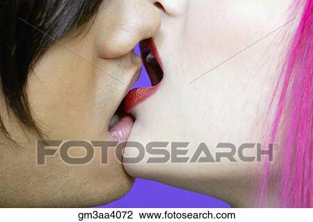 Stock Image - Extreme close up of young Hispanic couple kissing. Fotosearch