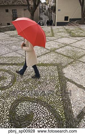 High angle view of woman walking with umbrella in urban setting View Large Photo Image Stock Photo - High angle view of woman walking with umbrella in urban setting. Fotosearch