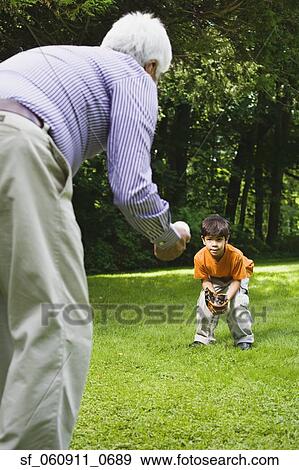 Hispanic boy playing catch with grandfather in park View Large Photo Image Stock Photo - Hispanic boy playing catch with grandfather in park. Fotosearch