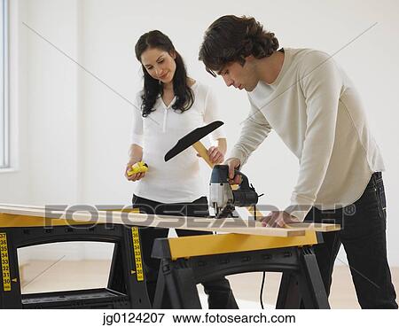 Hispanic couple drilling wood View Large Photo Image Stock Photo - Hispanic couple drilling wood. Fotosearch
