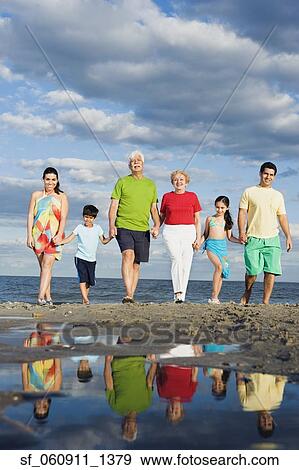 Hispanic family holding hands and walking on beach View Large Photo Image Stock Photo - Hispanic family holding hands and walking on beach. Fotosearch