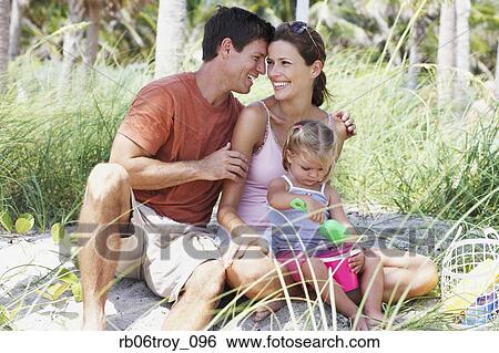 Hispanic family sitting on beach playing View Large Photo Image Stock Photograph - Hispanic family sitting on beach playing. Fotosearch