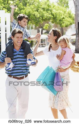 Hispanic family walking with shopping bags outdoors View Large Photo Image Stock Photograph - Hispanic family walking with shopping bags outdoors. Fotosearch