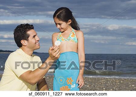 Hispanic father and daughter looking at seashell View Large Photo Image Stock Photo - Hispanic father and daughter looking at seashell. Fotosearch