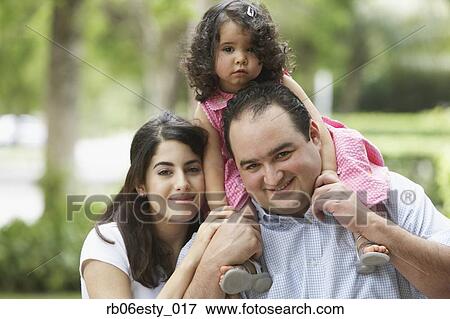 Hispanic father and mother with daughter on shoulders View Large Photo Image Stock Photo - Hispanic father and mother with daughter on shoulders. Fotosearch
