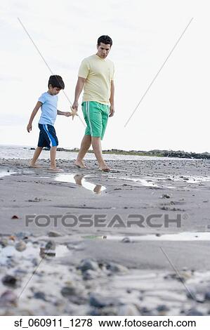 Hispanic father and son walking on beach with starfish View Large Photo Image Stock Photo - Hispanic father and son walking on beach with starfish. Fotosearch