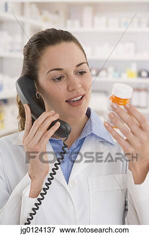 Hispanic female pharmacist talking on telephone View Large Photo Image Stock Photo - Hispanic female pharmacist talking on telephone. Fotosearch