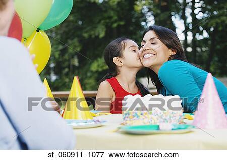 Hispanic girl kissing mother’s cheek at birthday party View Large Photo Image Stock Photo - Hispanic girl kissing mother’s cheek at birthday party. Fotosearch