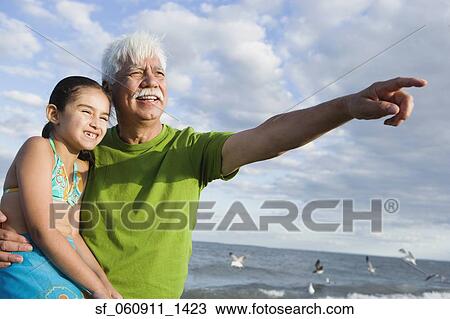 Hispanic grandfather with granddaughter pointing into the distance View Large Photo Image Stock Image - Hispanic grandfather with granddaughter pointing into the distance. Fotosearch