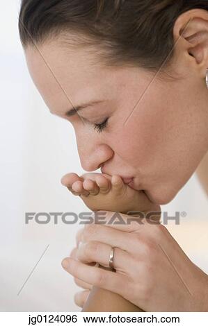 Hispanic mother kissing baby’s foot View Large Photo Image Stock Photograph - Hispanic mother kissing baby’s foot. Fotosearch