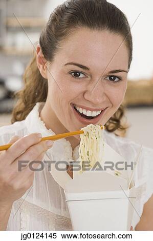 Hispanic woman eating noodles with chopsticks View Large Photo Image Stock Photography - Hispanic woman eating noodles with chopsticks. Fotosearch