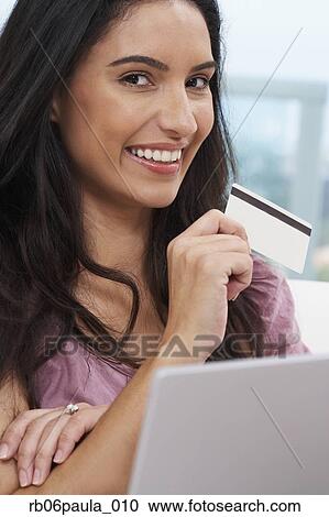 Stock Image - Hispanic woman holding credit card. Fotosearch
