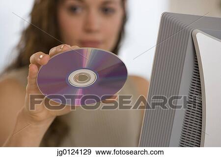 Hispanic woman holding up cd View Large Photo Image Stock Photo - Hispanic woman holding up cd. Fotosearch