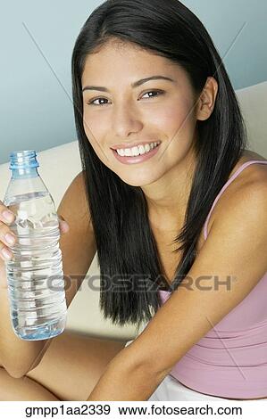 Hispanic woman holding water bottle View Large Photo Image Stock Photo - Hispanic woman holding water bottle. Fotosearch