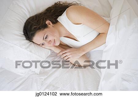 Hispanic woman laying in bed View Large Photo Image Stock Image - Hispanic woman laying in bed. Fotosearch