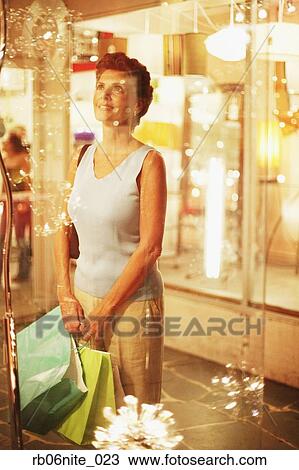 Hispanic woman with shopping bags looking in shop window View Large Photo Image Stock Image - Hispanic woman with shopping bags looking in shop window. Fotosearch