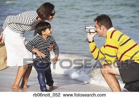 Indian father video recording wife and son at beach View Large Photo Image Stock Image - Indian father video recording wife and son at beach. Fotosearch