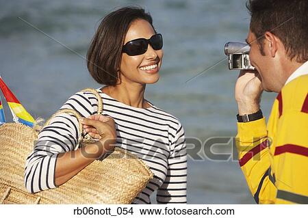 Indian man video recording girlfriend at beach View Large Photo Image Picture - Indian man video recording girlfriend at beach. Fotosearch