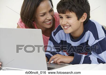 Indian mother and son using laptop View Large Photo Image Stock Photograph - Indian mother and son using laptop. Fotosearch