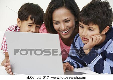 Indian mother and sons using laptop View Large Photo Image Stock Photo - Indian mother and sons using laptop. Fotosearch