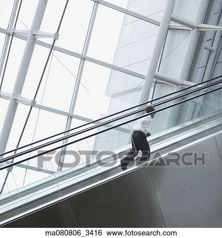 Low angle view of African boy going up escalator View Large Photo Image Stock Photograph - Low angle view of African boy going up escalator. Fotosearch