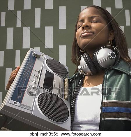 Low angle view of African woman listening to music on portable stereo View Large Photo Image Stock Photography - Low angle view of African woman listening to music on portable stereo. Fotosearch