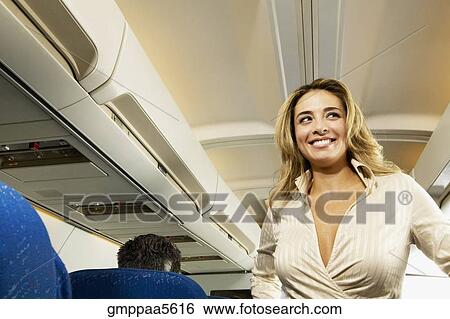 Low angle view of woman in aisle of airplane View Large Photo Image Stock Photograph - Low angle view of woman in aisle of airplane. Fotosearch