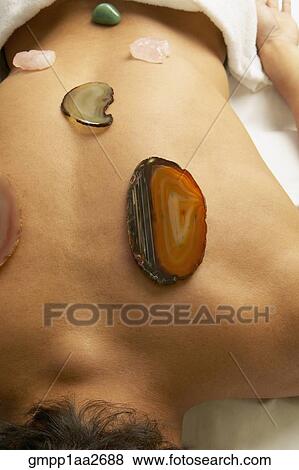 Man receiving stone and crystal spa treatment on back View Large Photo Image Stock Photo - Man receiving stone and crystal spa treatment on back. Fotosearch