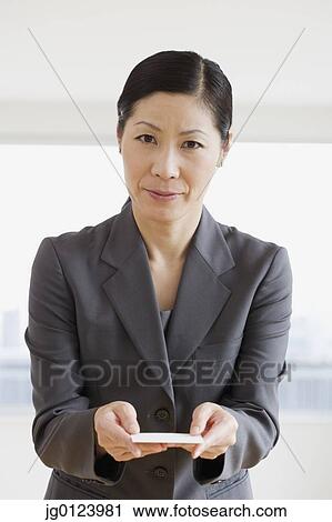 Middle-aged Asian businesswoman offering business card View Large Photo Image Stock Image - Middle-aged Asian businesswoman offering business card. Fotosearch