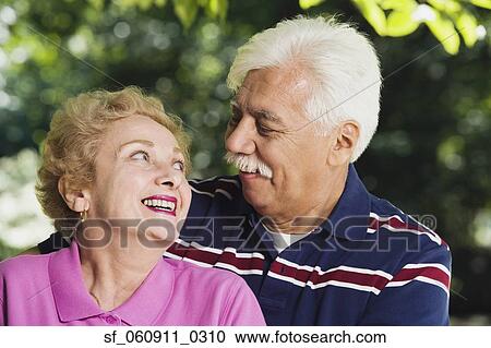 Stock Image - Senior Hispanic couple smiling at each other. Fotosearch