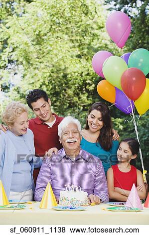 Senior Hispanic man with family and birthday cake View Large Photo Image Stock Photo - Senior Hispanic man with family and birthday cake. Fotosearch